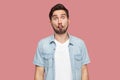 Portrait of funny comic face handsome bearded young man in blue casual style shirt standing with fish lips and looking at camera Royalty Free Stock Photo