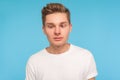 Portrait of funny comic young man in casual white t-shirt looking cross-eyed with awkward silly dumb expression