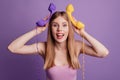 Portrait of funny crazy girlish lady hold telephone fooling around posing wear pink top on violet background