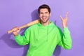 Portrait of funny crazy rock roll lover guy wear green hoodie excited hold baseball bat excited metal sign isolated on
