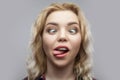 Portrait of funny crazy young beautiful blonde woman in casual red checkered shirt standing and looking with crossed eyes and Royalty Free Stock Photo