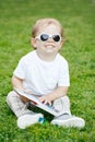 Portrait of funny cute adorable smiling laughing white Caucasian toddler child boy with blond hair in white t-shirt and sunglasses Royalty Free Stock Photo