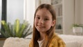 Portrait funny cute satisfied caucasian kid girl looking at camera in living room smiling toothy smile positive preteen Royalty Free Stock Photo