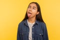 Portrait of funny dumb crazy girl in denim shirt showing tongue out and looking cross-eyed with silly brainless expression