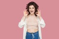 Portrait of funny excited beautiful brunette young woman with curly hairstyle in casual style standing with Ok or peace sign and Royalty Free Stock Photo