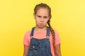 Portrait of funny frustrated naughty little girl looking at camera with comical resentful unhappy face expression