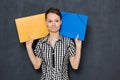 Portrait of funny frustrated sad woman holding folders near head