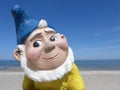 Portrait of a funny garden gnome in front of blue sky