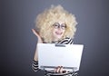 Portrait of funny girl in blonde wig with laptop. Royalty Free Stock Photo