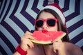 Portrait of a funny girl in Santa Claus hat and red sunglasses Royalty Free Stock Photo