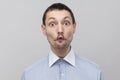 Portrait of funny handsome bristle businessman in classic blue shirt standing looking at camera with surprised face, big eyes and Royalty Free Stock Photo