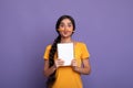 Funny indian lady holding pen as moustache over purple wall