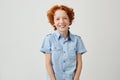 Portrait of funny little boy with red hair and freckles smiling brightfully, looking in camera, posing for family photo Royalty Free Stock Photo