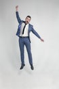 Portrait of a funny and little crazy businessman man jumping and cheering loud on a white background
