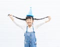 Portrait of funny little cute asian girl smiling and holding hairs .Crazy Asian child preschool  wearing T-shirt and blue jeans on Royalty Free Stock Photo