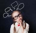 Portrait of funny little girl with empty speech clouds chalk