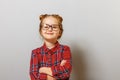 Portrait of a funny little preschool child girl in glasses on gray background. Education. Back to school