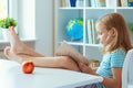 Portrait of funny little school girl relaxing reads book at the