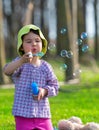 Portrait of funny lovely little girl blowing soap bubbles in the park Royalty Free Stock Photo