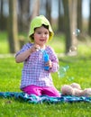 Portrait of funny lovely little girl blowing soap bubbles in the park Royalty Free Stock Photo