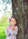 Portrait of funny lovely little girl blowing soap bubbles in the park Royalty Free Stock Photo