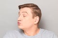 Portrait of funny mature man pouting his lips and blowing kiss