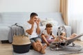 Portrait of funny man wearing white casual style T-shirt and jeans short sitting on floor with his children, father playing peek-a Royalty Free Stock Photo