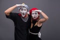 Portrait of funny mime couple with white faces and