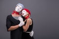 Portrait of funny mime couple with white faces and