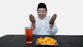 Portrait of overweight muslim man with head cap or songkok pray before eat and drink for islam break fasting Royalty Free Stock Photo