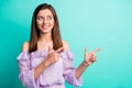 Portrait of funny optimistic girl pointing empty space wear purple shirt isolated on blue color background Royalty Free Stock Photo