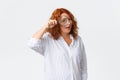 Portrait of funny and pretty middle-aged redhead woman searching for employee or perfect candidates, looking through