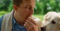 Portrait of funny dog sniffing eating man. Labrador trying taste cheese closeup. Royalty Free Stock Photo