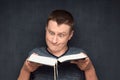 Portrait of funny and puzzled man reading big book Royalty Free Stock Photo