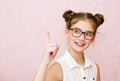 Portrait of funny smiling little girl child wearing glasses with finger up isolated Royalty Free Stock Photo