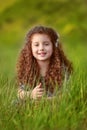 Portrait of Funny smiling little girl with curly hair in green g Royalty Free Stock Photo