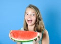 Portrait of a funny teen girl with a big piece of ripe watermelon.