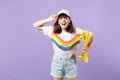 Portrait of funny teen girl in vivid clothes looking camera, holding yellow skateboard isolated on violet pastel Royalty Free Stock Photo