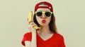 Portrait funny woman calling on a banana phone on a white background