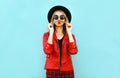 Portrait funny woman showing moustache her hair blowing red lips having fun in black round hat, red jacket on blue Royalty Free Stock Photo