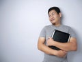 Funny Asian Man Holding Laptop, Thinking and Smiling With Copy Space Royalty Free Stock Photo