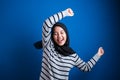 Portrait of a funny young Asian muslim girl wearing hijab dancing happily Royalty Free Stock Photo