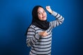 Portrait of a funny young Asian muslim girl wearing hijab dancing happily joyful expressing celebrating good news Royalty Free Stock Photo