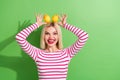 Portrait of funny young positive model woman good mood hands holding on head citrus lemons bunny isolated on green color Royalty Free Stock Photo