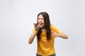 Portrait of a furious asian woman talking on mobile phone over white background