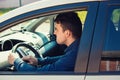 Portrait of furious male driver sitting in the car and honking the car horn angry on the driver ahead Royalty Free Stock Photo