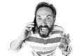 Furious man crying at mobile phone. Mad irritated bearded man holding and shouting off