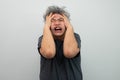 Portrait of a furious senior grey-haired man yelling and screaming and gesturing in fear with hands and face on isolated Royalty Free Stock Photo