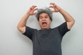 Portrait of a furious senior grey-haired man yelling and screaming and gesturing in fear with hands and face on isolated Royalty Free Stock Photo