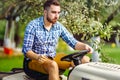 Portrait of gardener using a lawn mowing tractor for cutting grass. Royalty Free Stock Photo